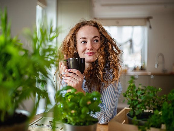Welcher Tee hilft bei Erkältungen? Rothaarige Frau mit Teetasse in der Hand