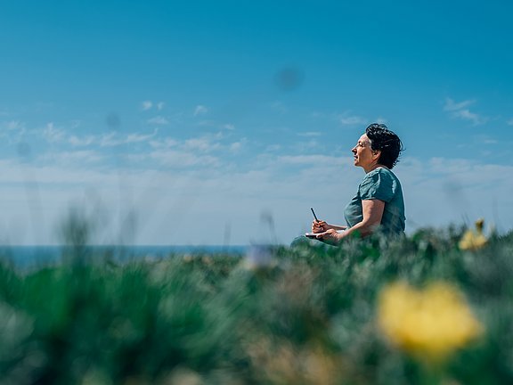 Hübner Herz-Kreislauf Frau meditiert in der Natur